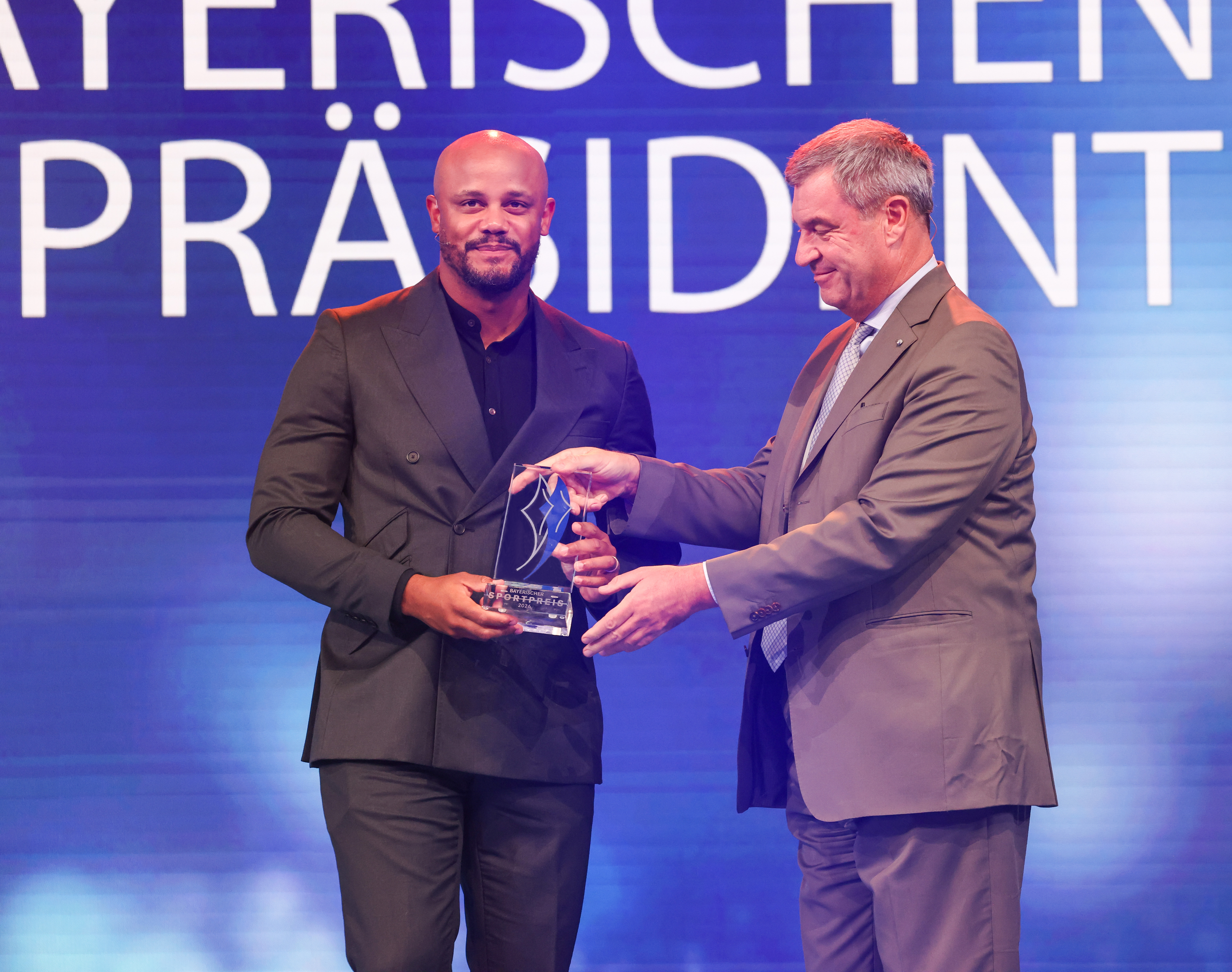 Bayerns Ministerpräsident Markus Söder überreicht eine gläserne Trophäe bei der Verleihung des Bayerischen Sportpreises 2026.